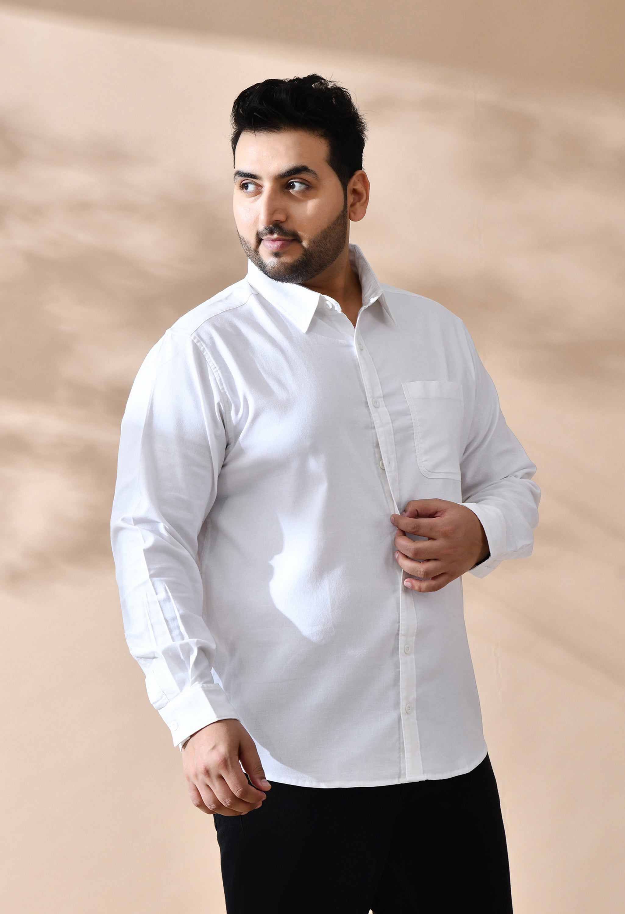 Man wearing a white shirt against a beige background