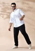 Man wearing a white shirt, black pants, and glasses on a beige background